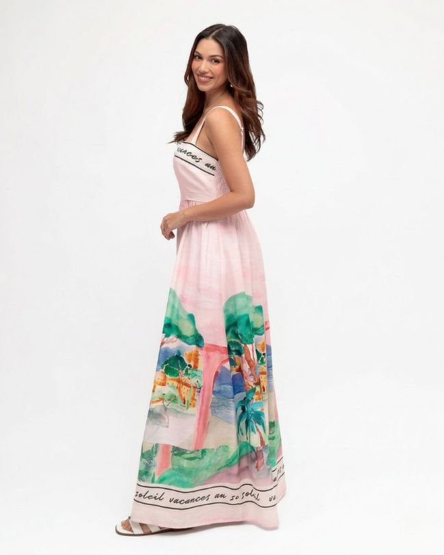 Woman wearing a pink dress with colorful floral pattern on a white background