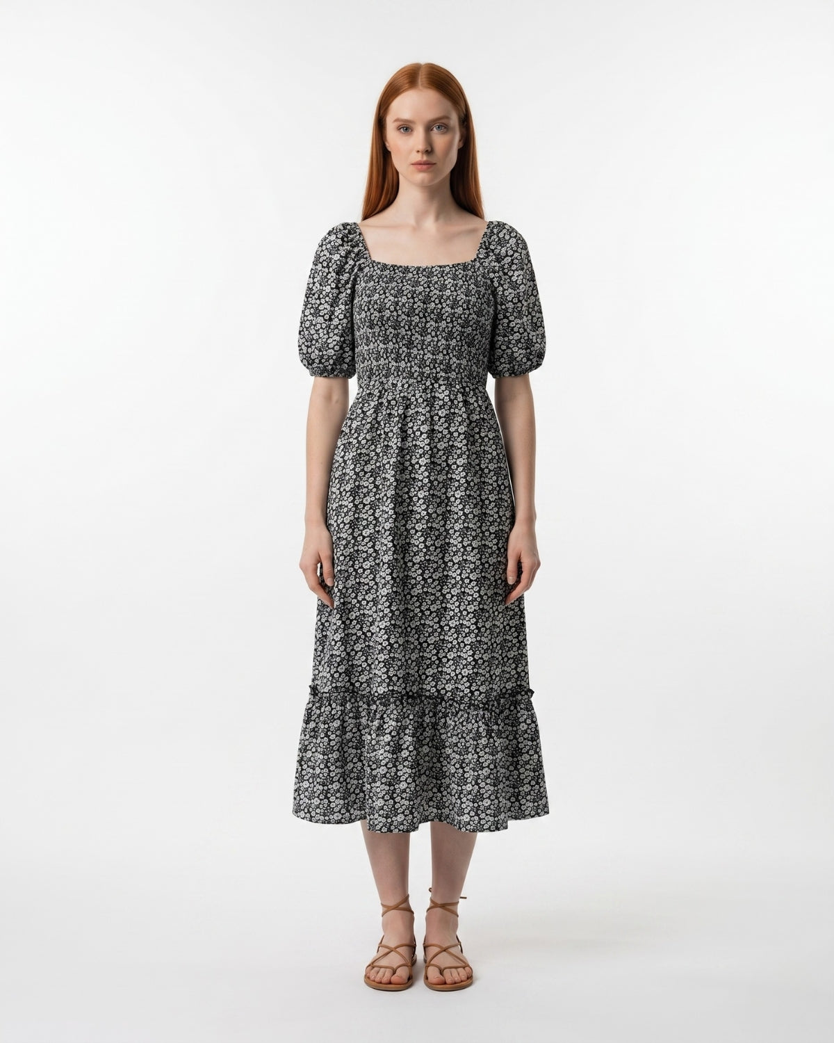 Woman wearing a black and white patterned dress on a white background