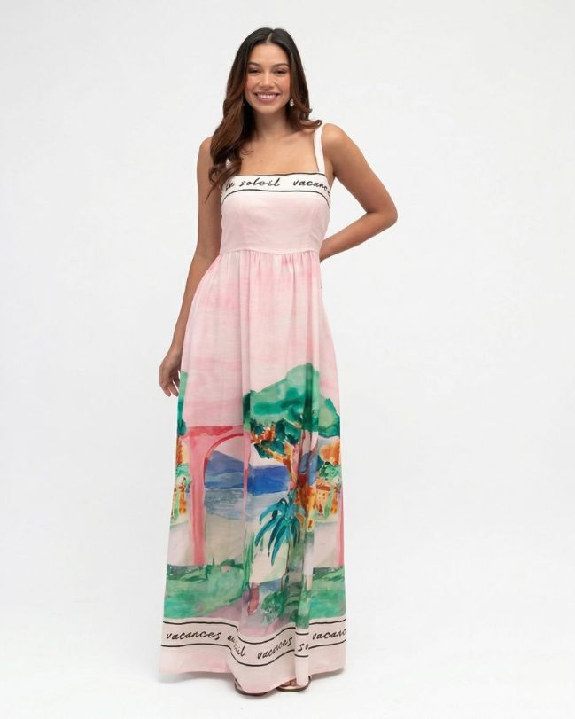 Woman wearing a pink dress with a scenic print on a white background