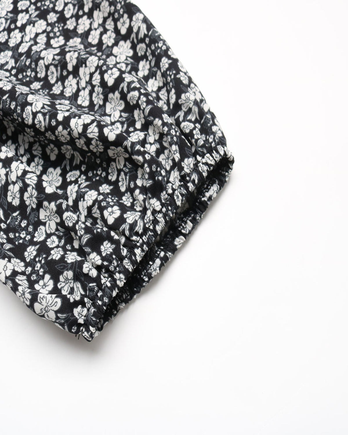 Black fabric with white floral pattern on a white background