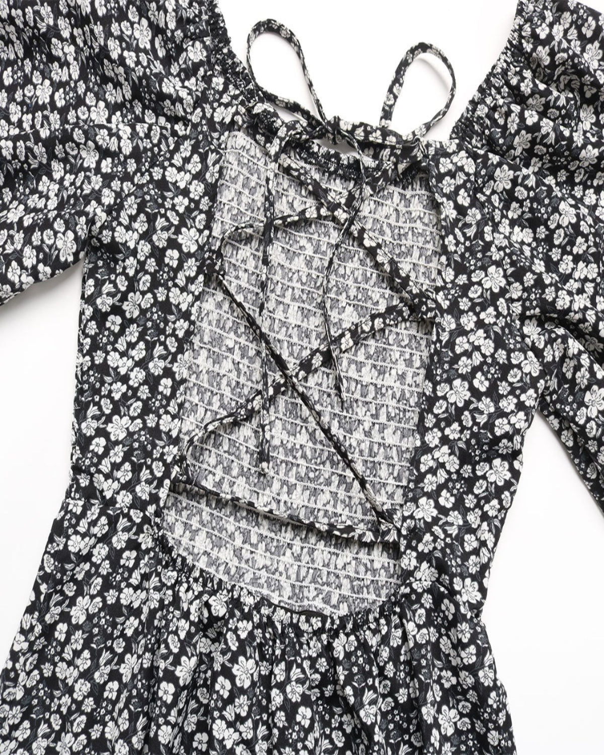 Black floral dress with a textured overlay on a white background