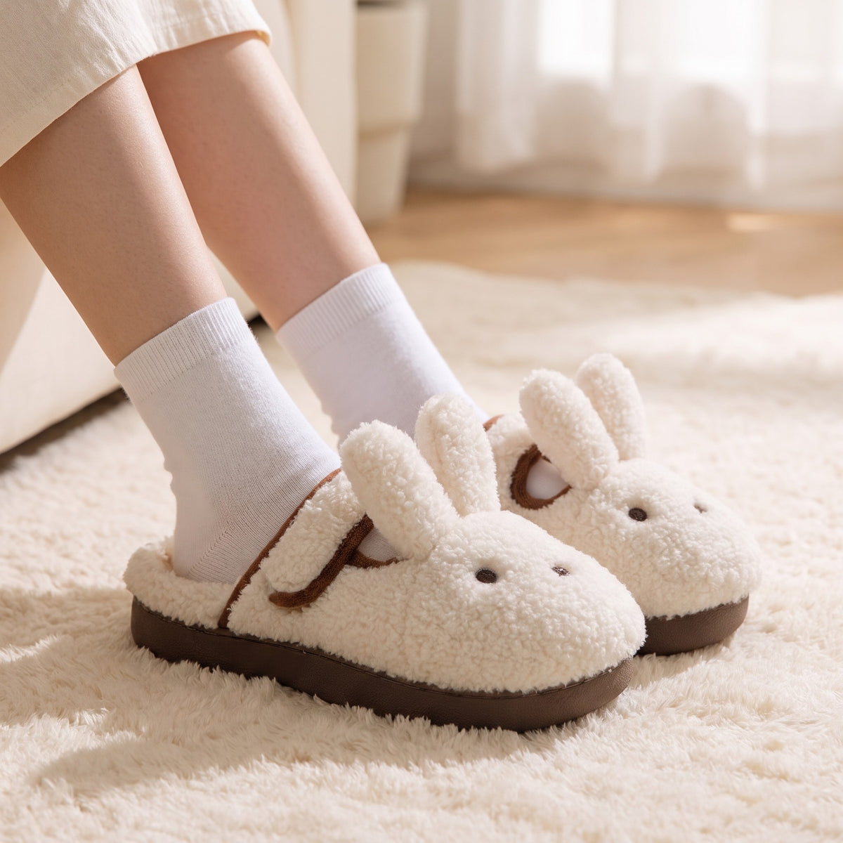 Feet in white socks wearing cream bunny slippers on a fluffy rug