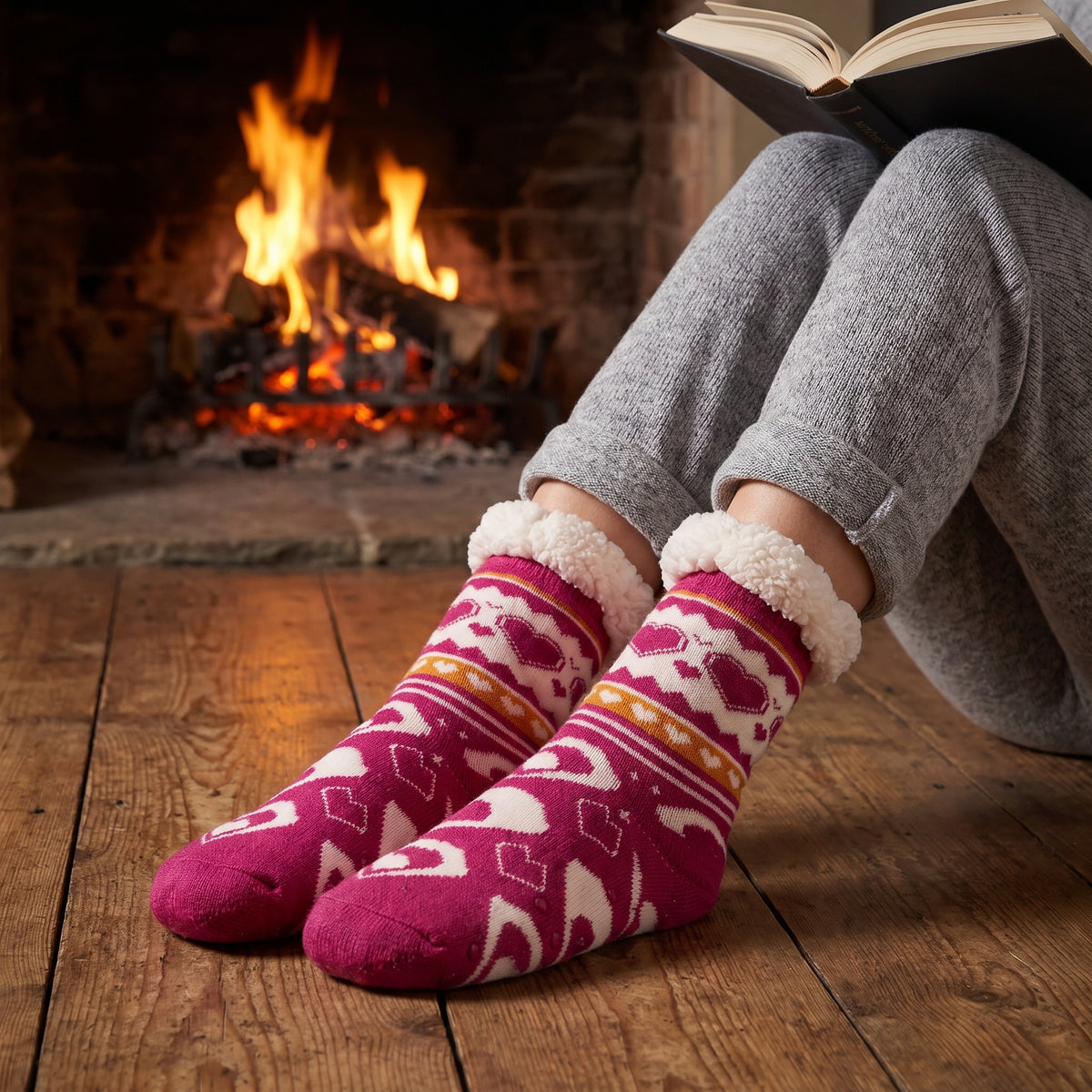 Raspberry heart fluffy socks by a cosy fireplace