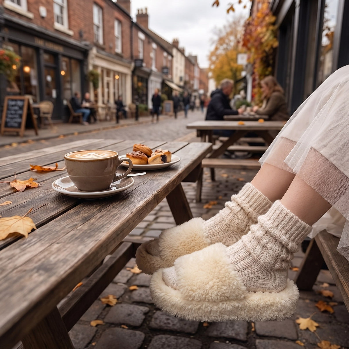Cream fuzzy platform slides with socks at an outdoor café table