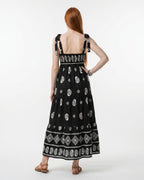 Woman wearing a black dress with white patterns on a white background