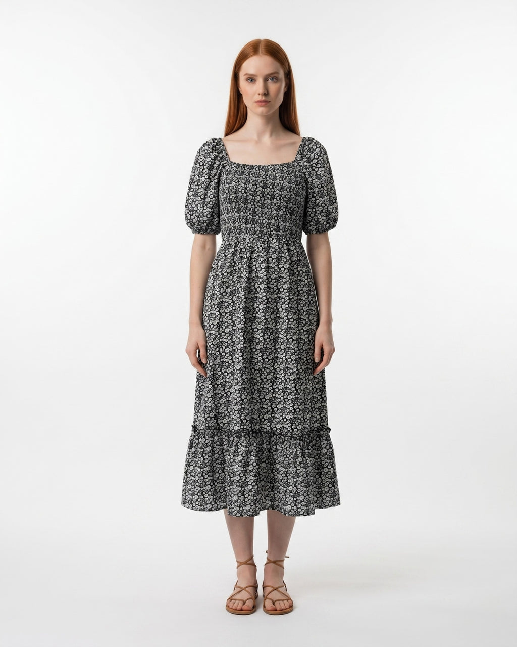 Woman wearing a black and white patterned dress on a white background