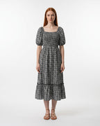 Woman wearing a black and white patterned dress on a white background