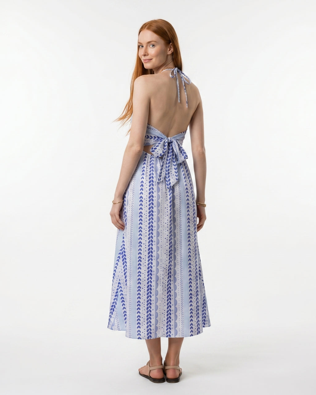 Woman wearing a blue and white patterned dress on a white background