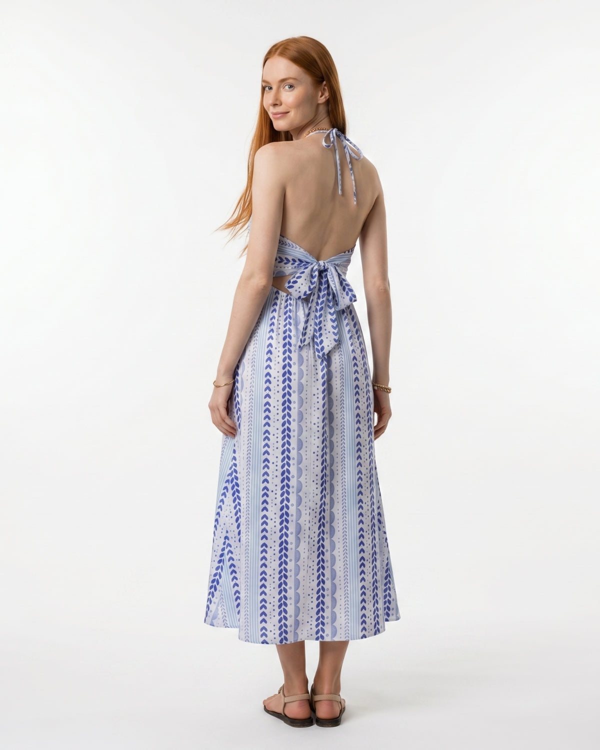 Woman wearing a blue and white patterned dress on a white background