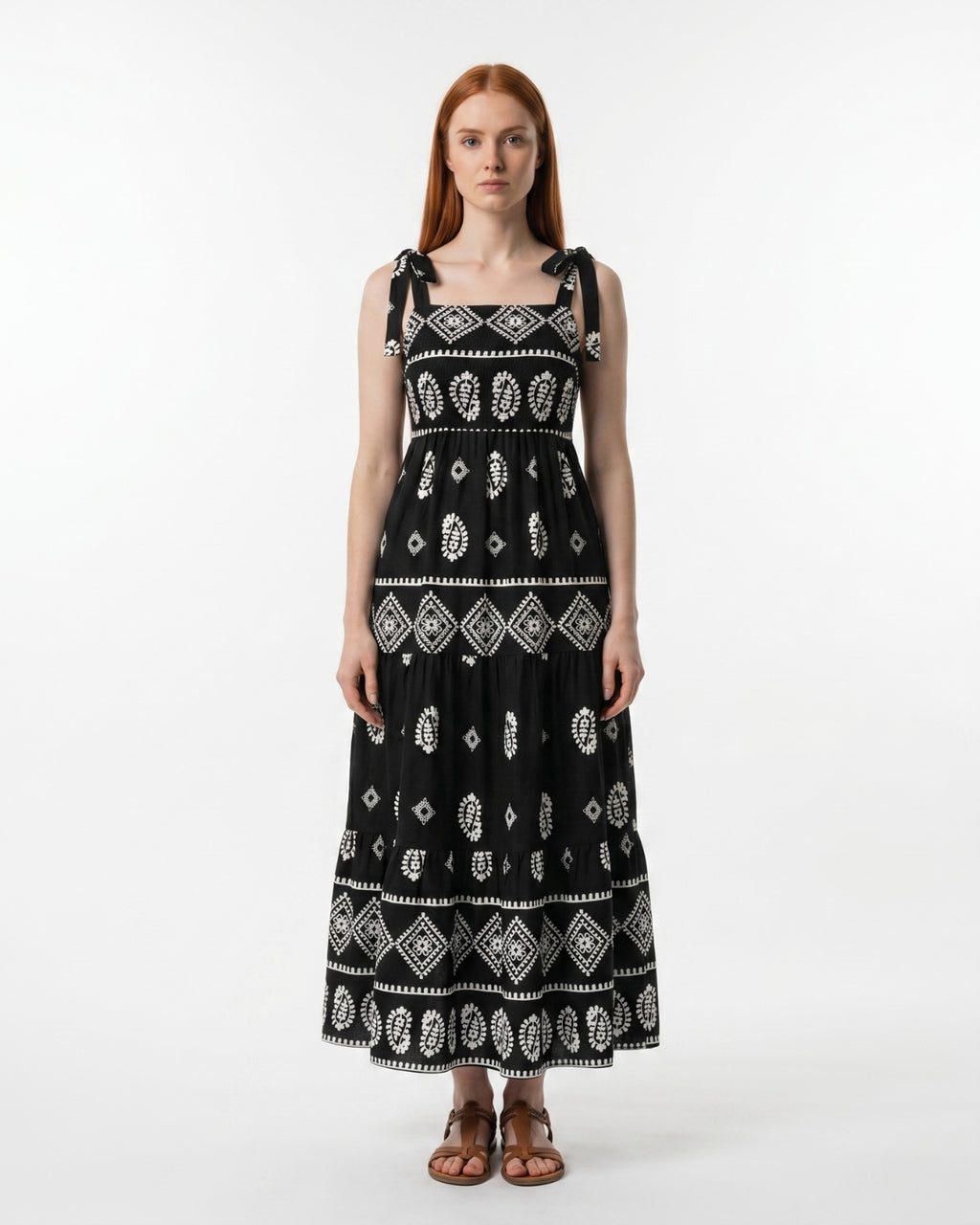 Woman wearing a black dress with white patterns on a white background