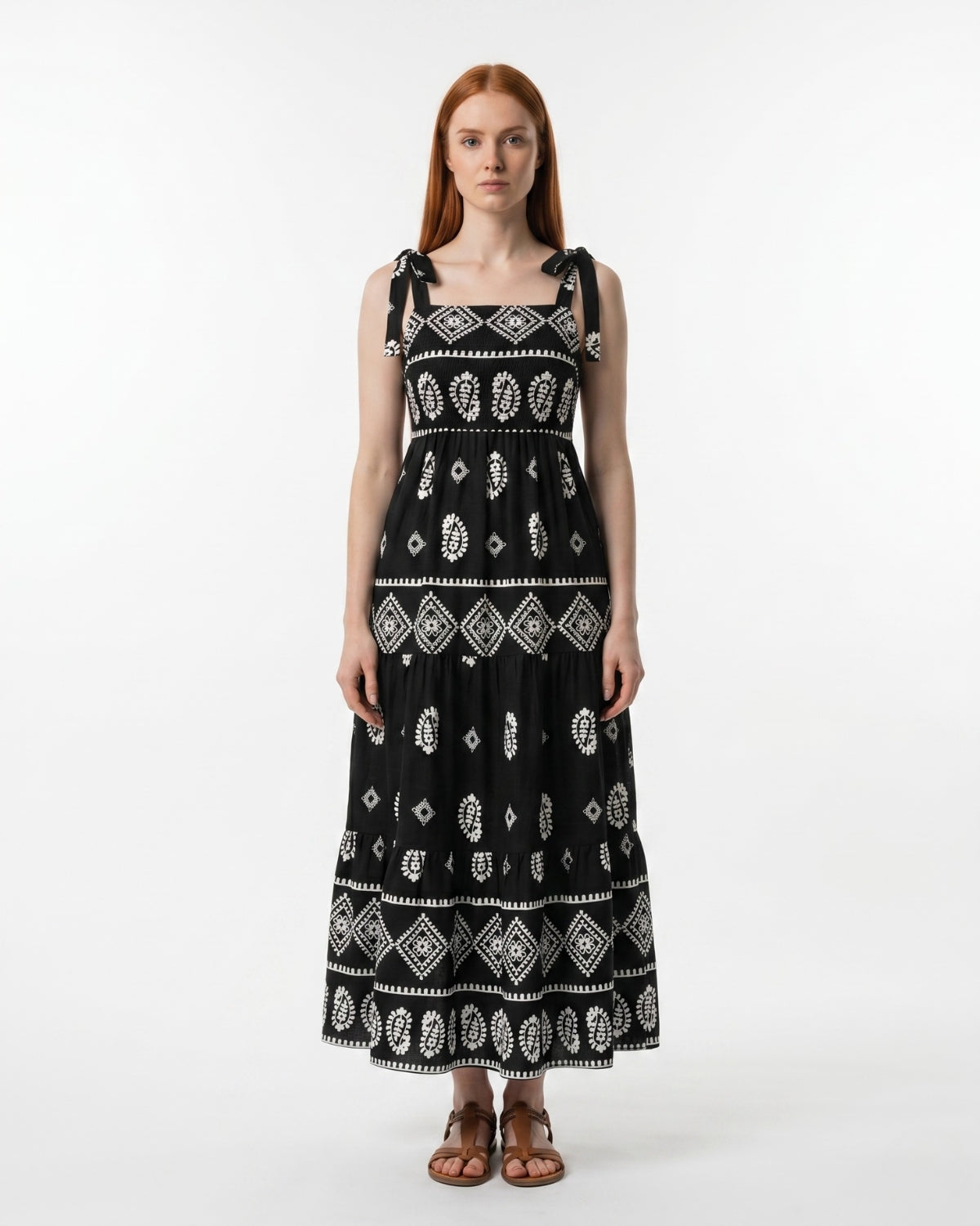 Woman wearing a black dress with white patterns on a white background
