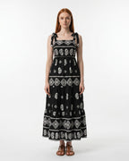 Woman wearing a black dress with white patterns on a white background