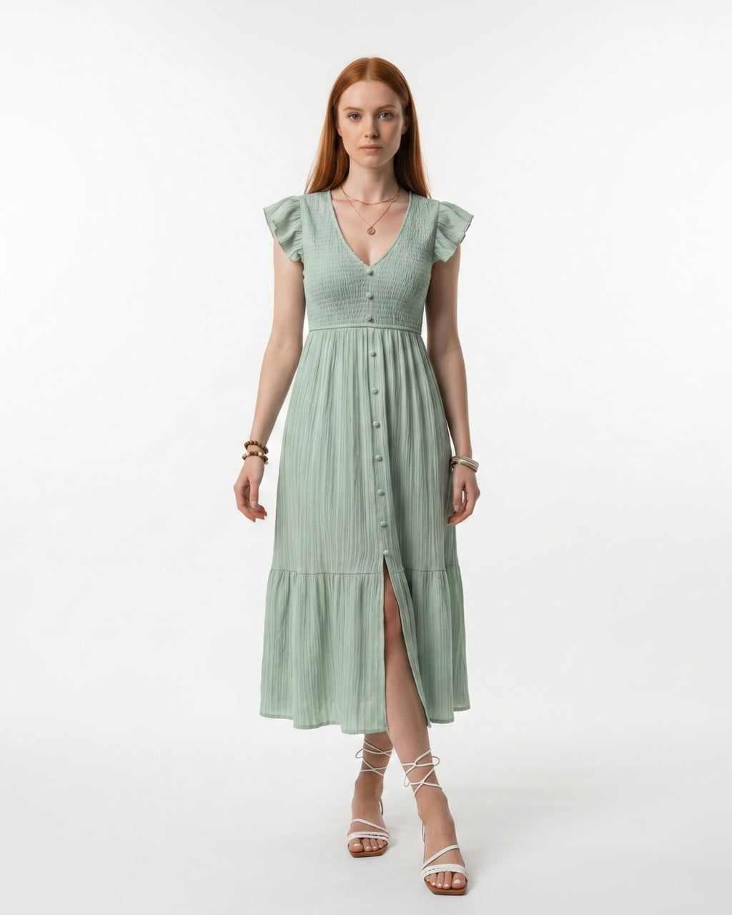 Woman wearing a light green dress with ruffled sleeves on a white background