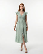 Woman wearing a light green dress with ruffled sleeves on a white background