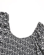 Black floral patterned top on a white background