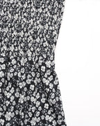 Black dress with white floral pattern on a white background
