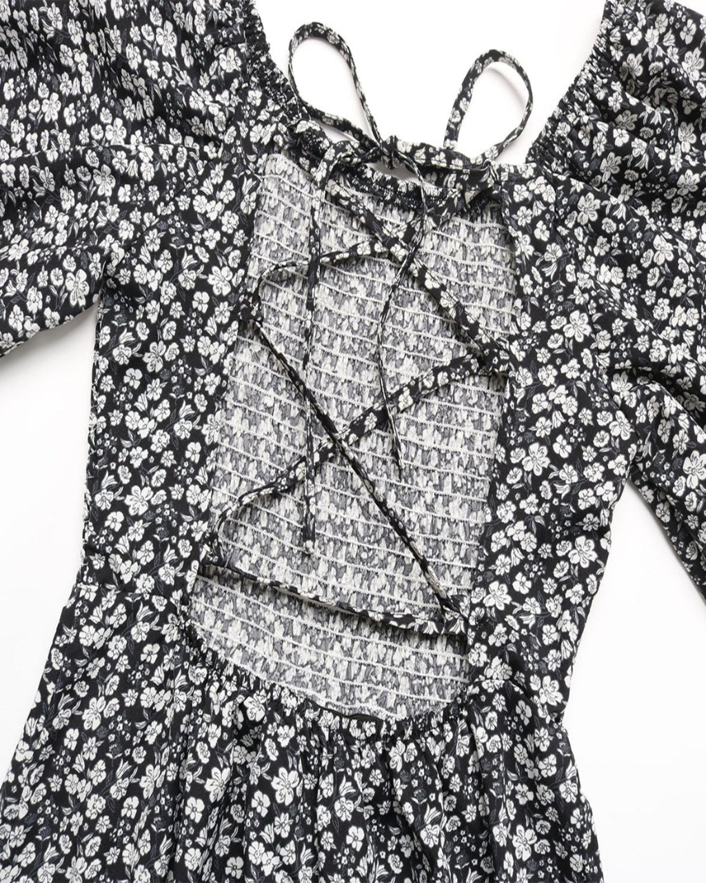 Black floral dress with a textured overlay on a white background