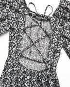 Black floral dress with a textured overlay on a white background