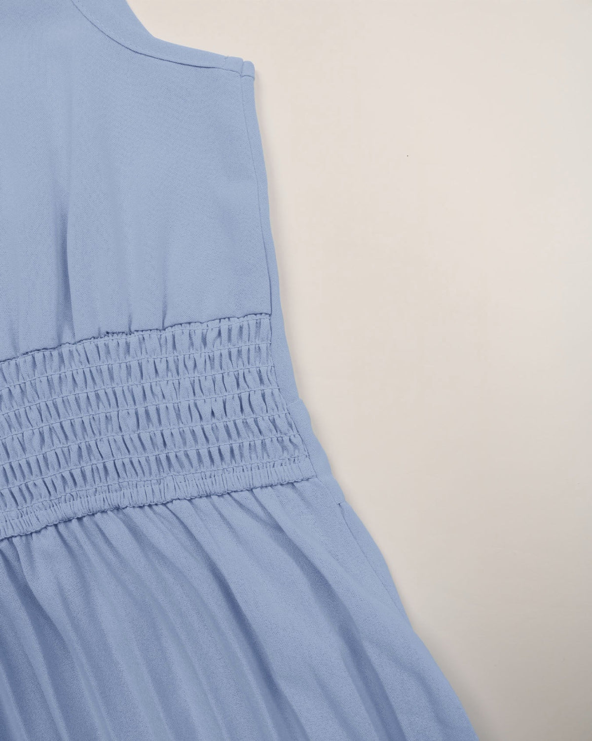 Light blue sleeveless dress on a beige background