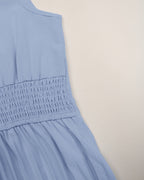 Light blue sleeveless dress on a beige background