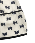Close-up of a white dress with black bow patterns on a white background