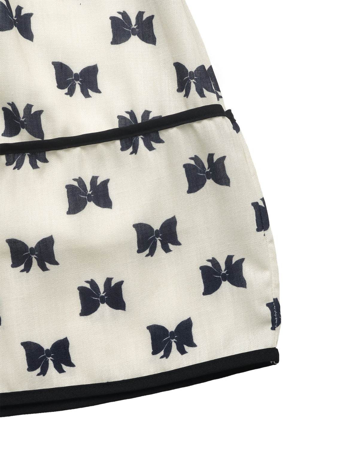 Close-up of a white dress with black bow patterns on a white background