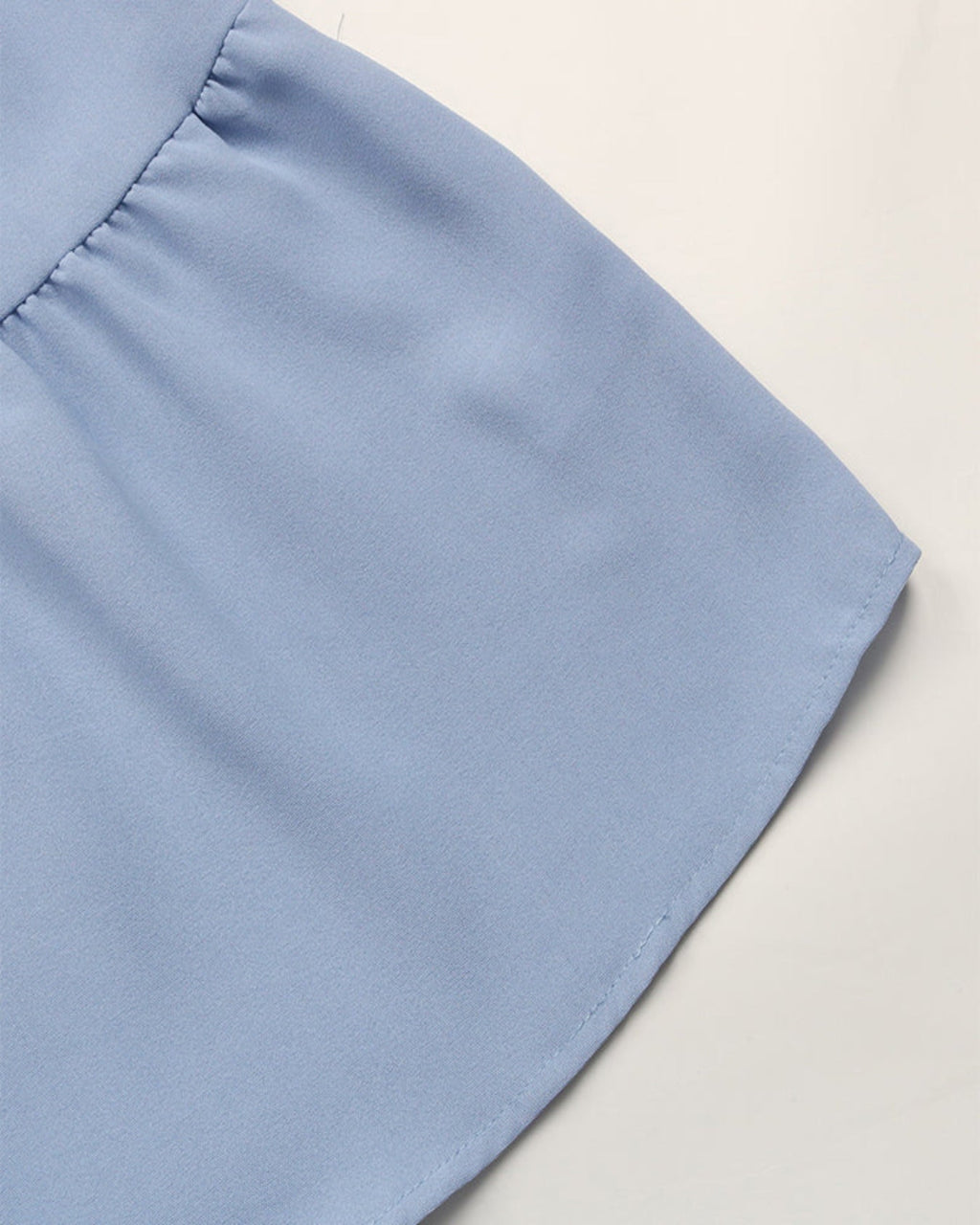 Close-up of a light blue fabric corner on a neutral background