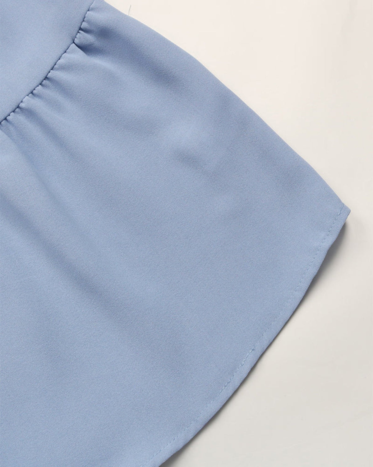 Close-up of a light blue fabric corner on a neutral background