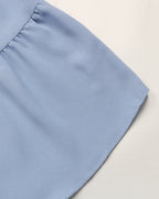Close-up of a light blue fabric corner on a neutral background