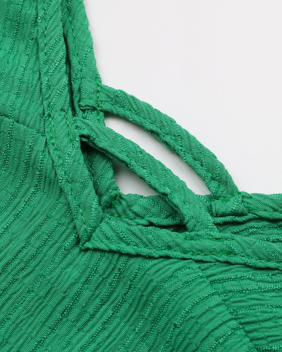 Close-up of a green textured fabric with cut-out design on a white background
