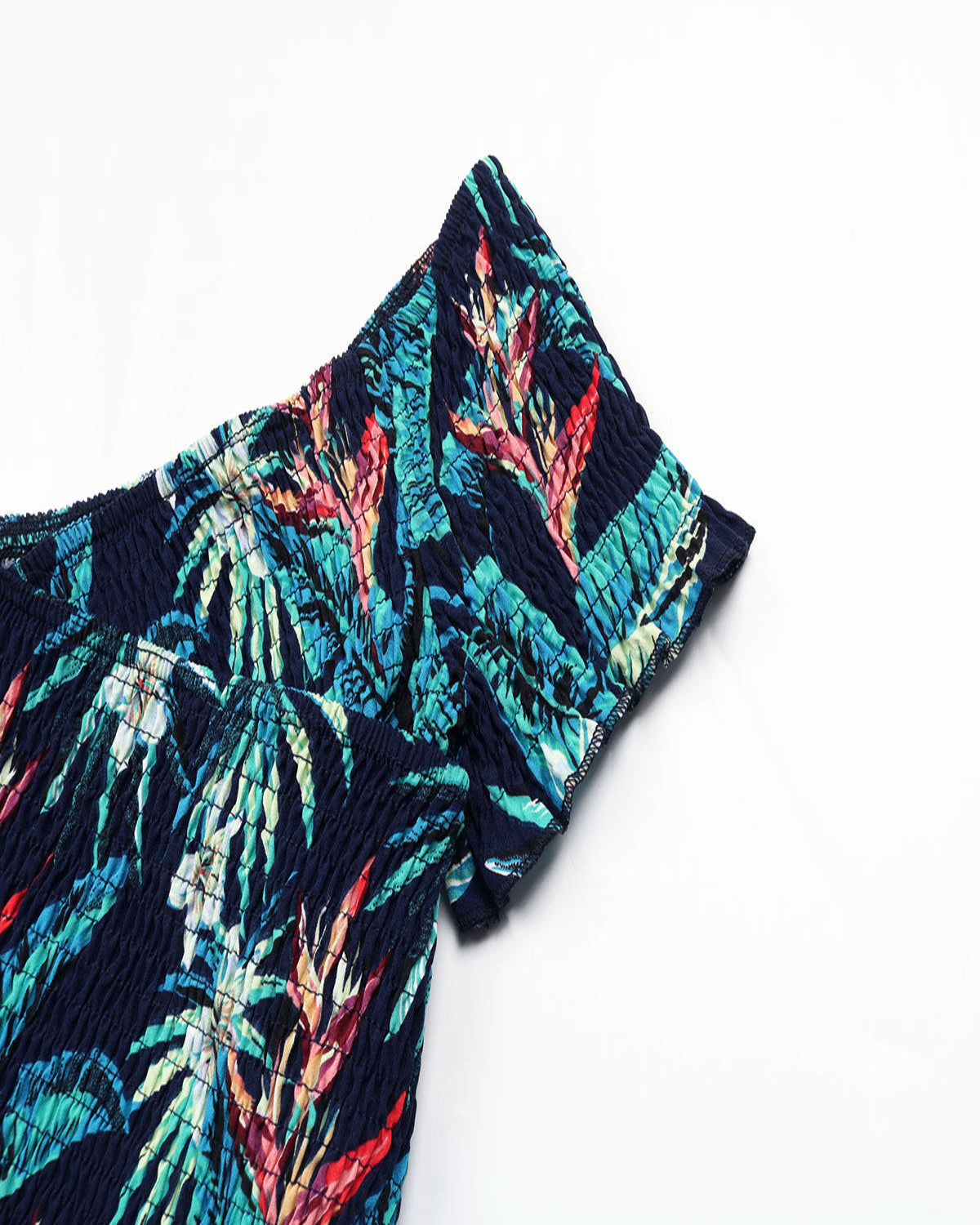 Tropical leaf patterned shorts on a white background