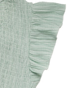 Light green textured fabric with ruffled edge on a white background
