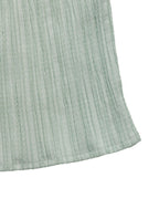 Close-up of a textured light green fabric corner on a white background