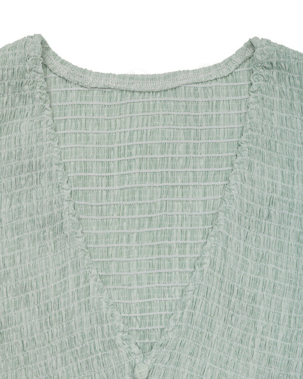Close-up of a textured green garment with a white background