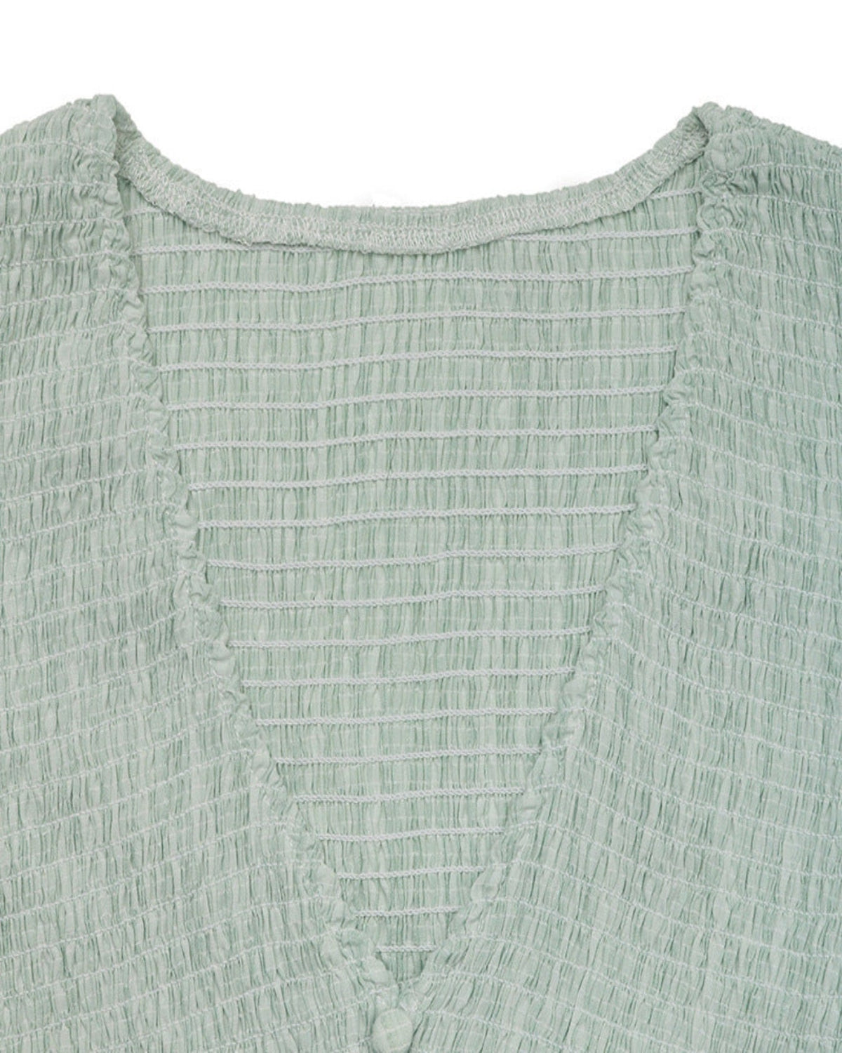 Close-up of a textured green garment with a white background