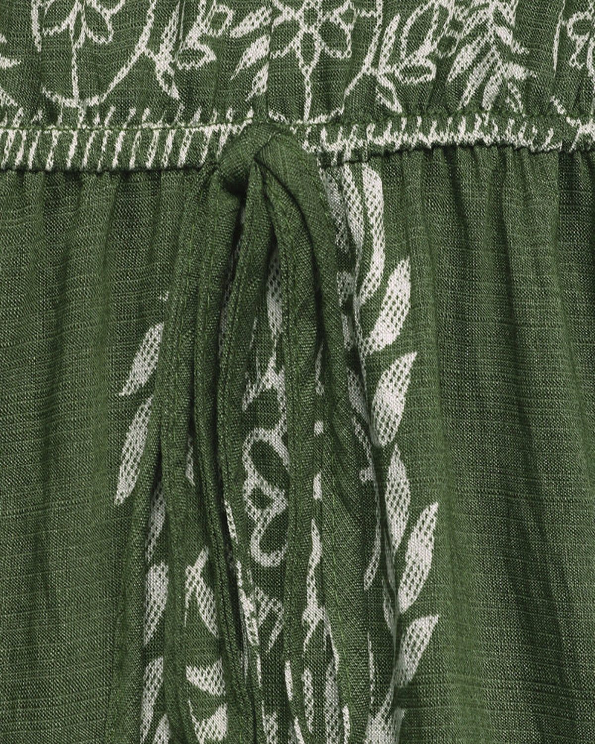 Green fabric with white floral embroidery