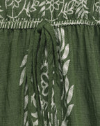 Green fabric with white floral embroidery