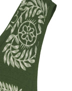 Green tie with white floral pattern on a white background