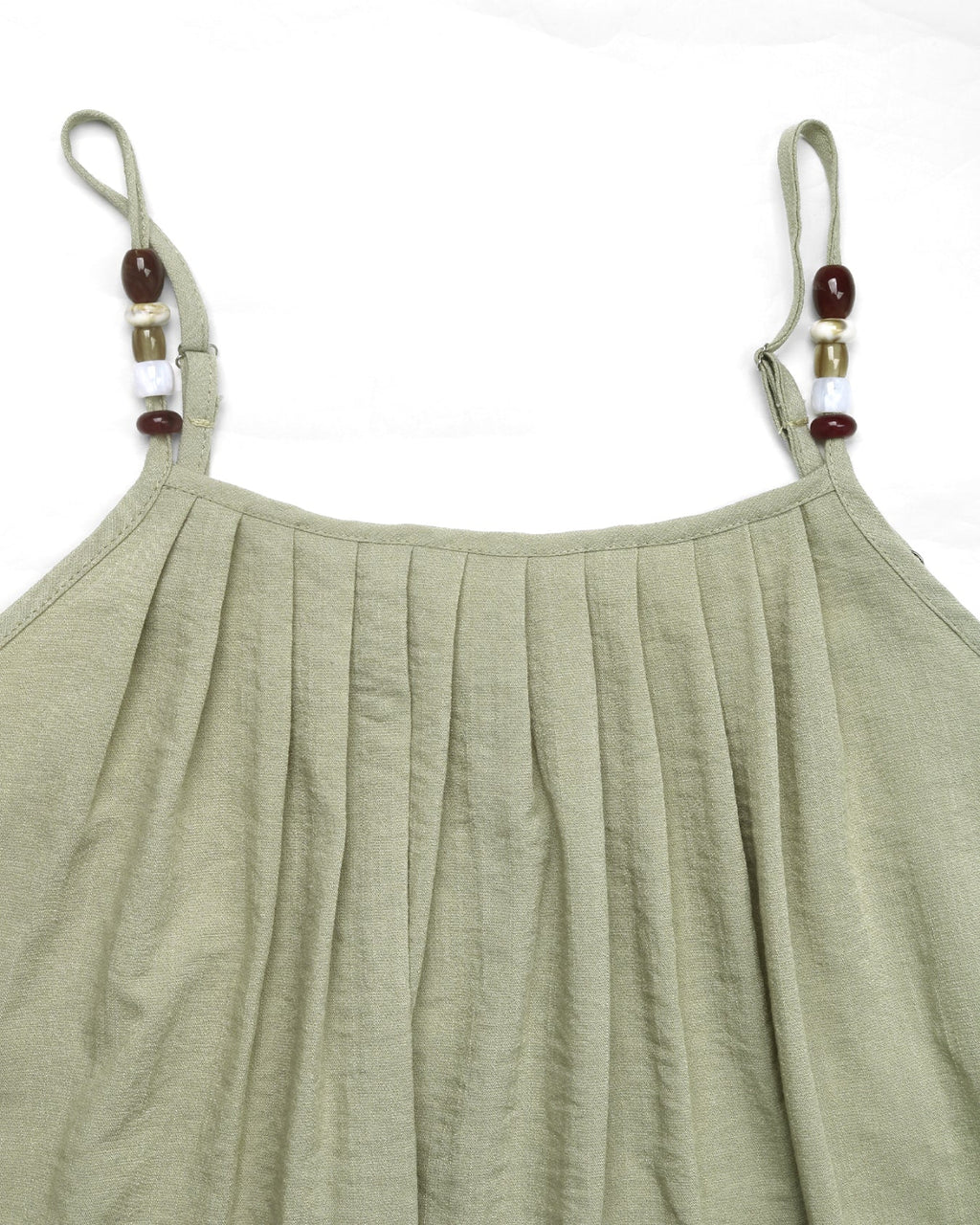 Green pleated dress with thin straps and bead details on a white background