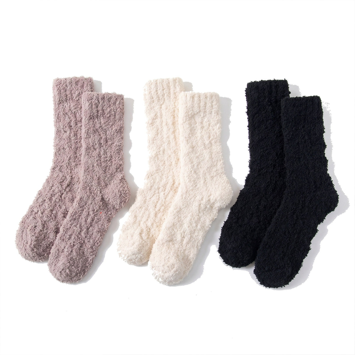Three pairs of fluffy bed socks in mauve, cream and black