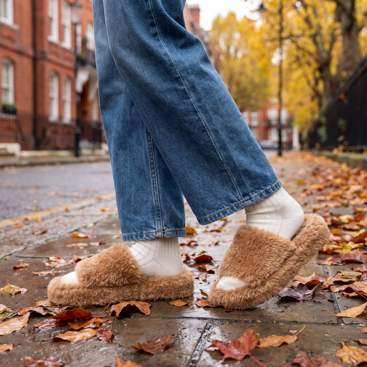 Woman in wide leg jeans wearing tan fuzzy platform slides on a London street