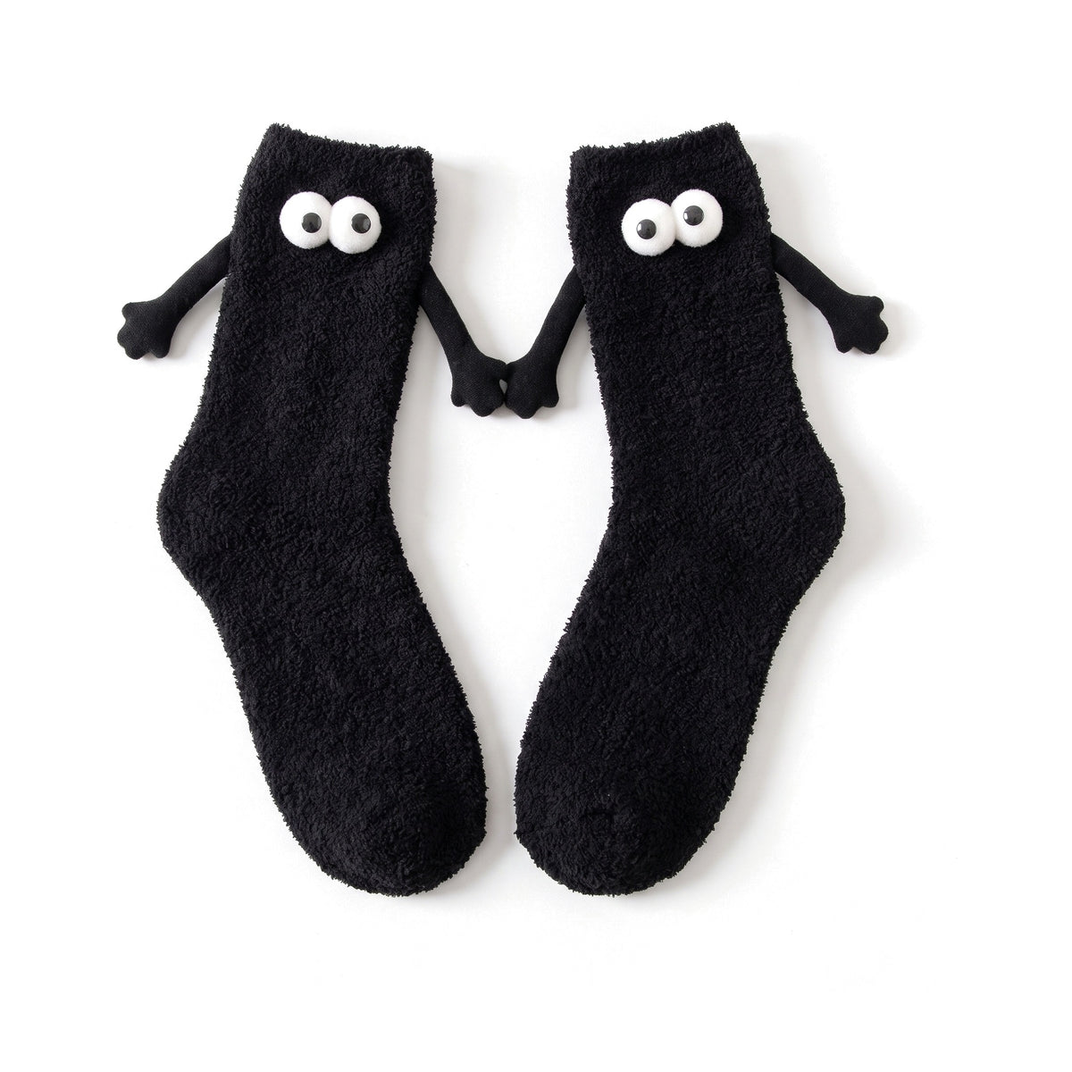 Black fluffy hand holding socks laid flat with magnetic hands touching