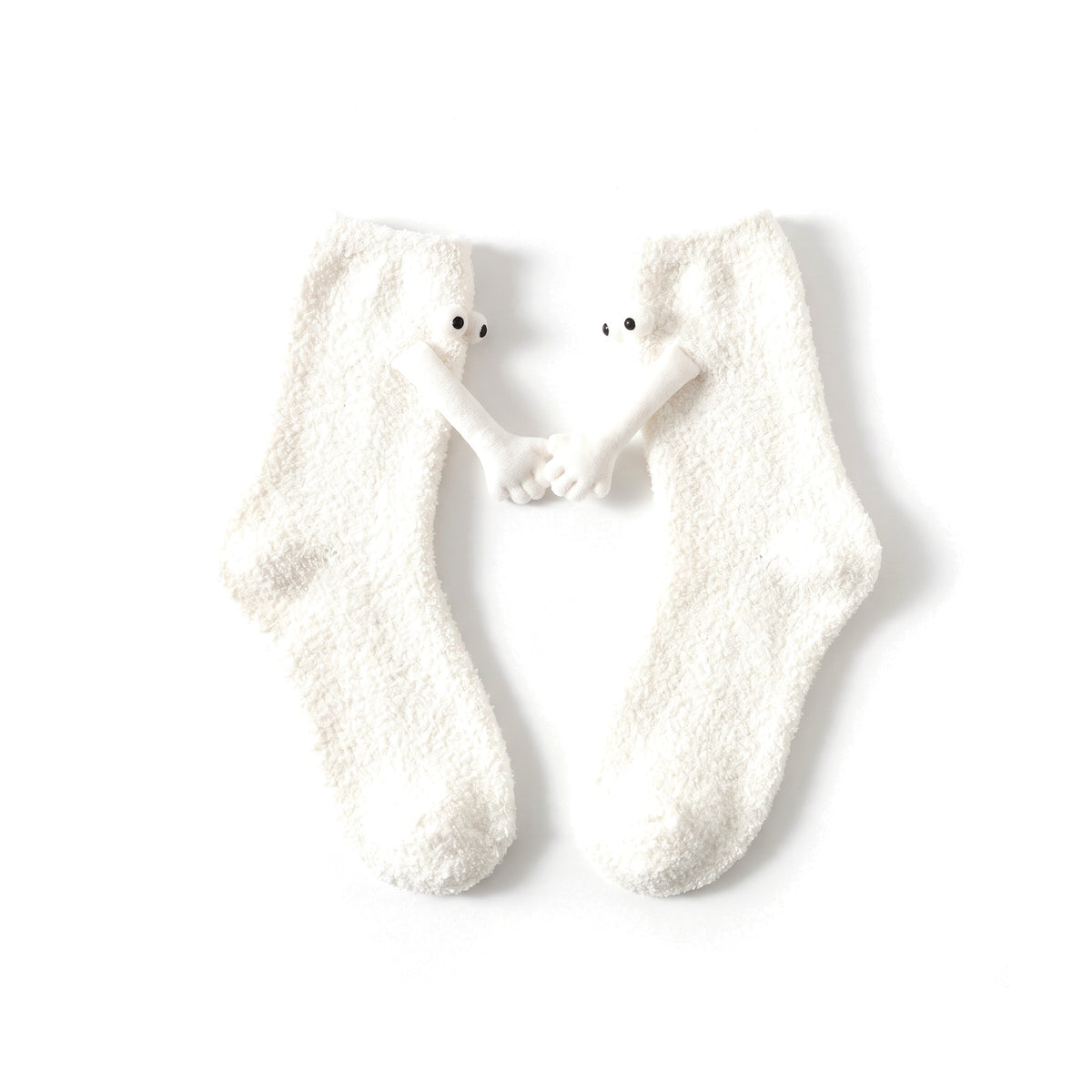 White fluffy hand holding socks laid flat with magnetic hands touching