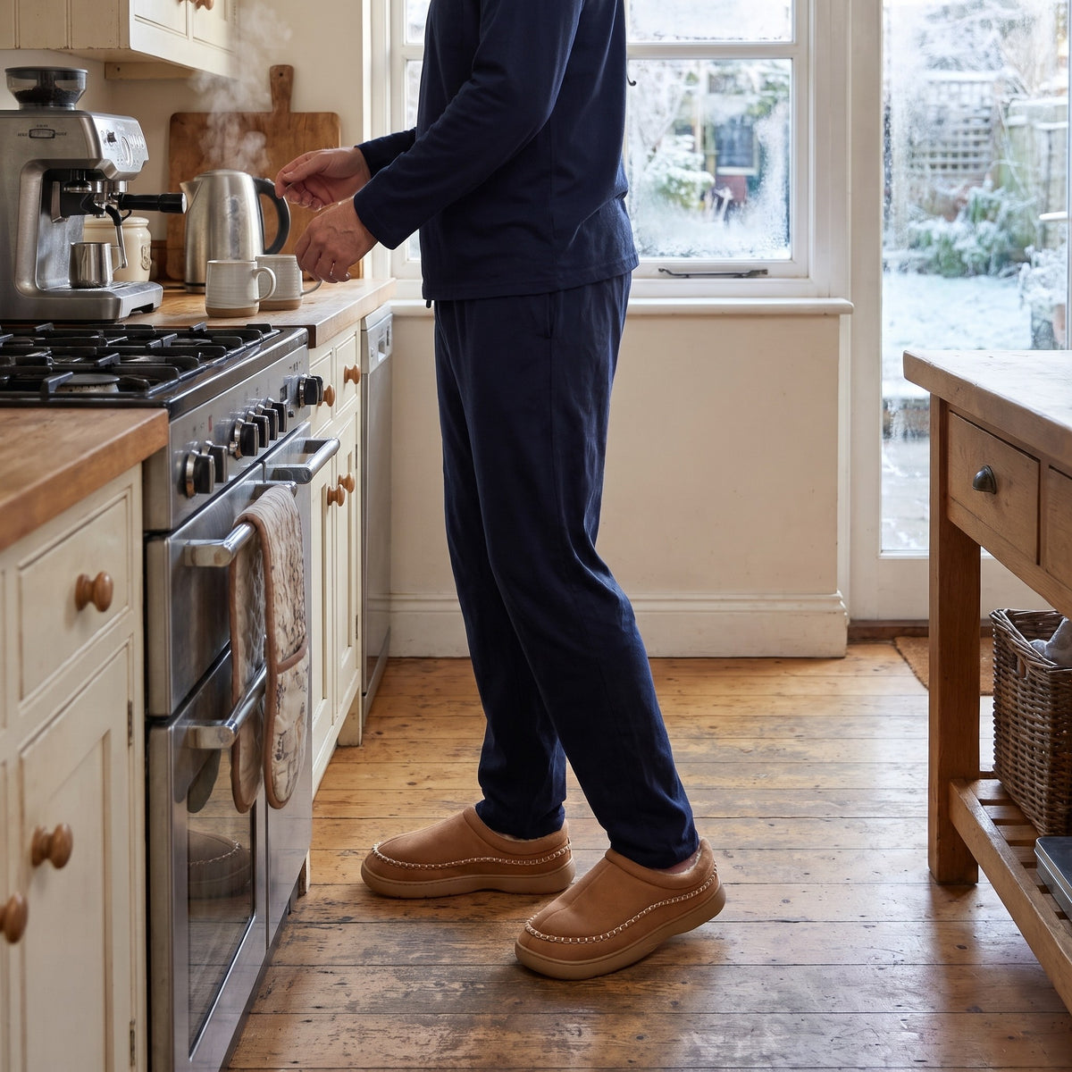 Man making coffee in the kitchen wearing tan moccasin clog slippers