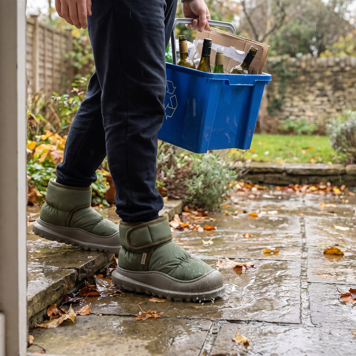 Olive green slipper boots worn on a wet garden patio