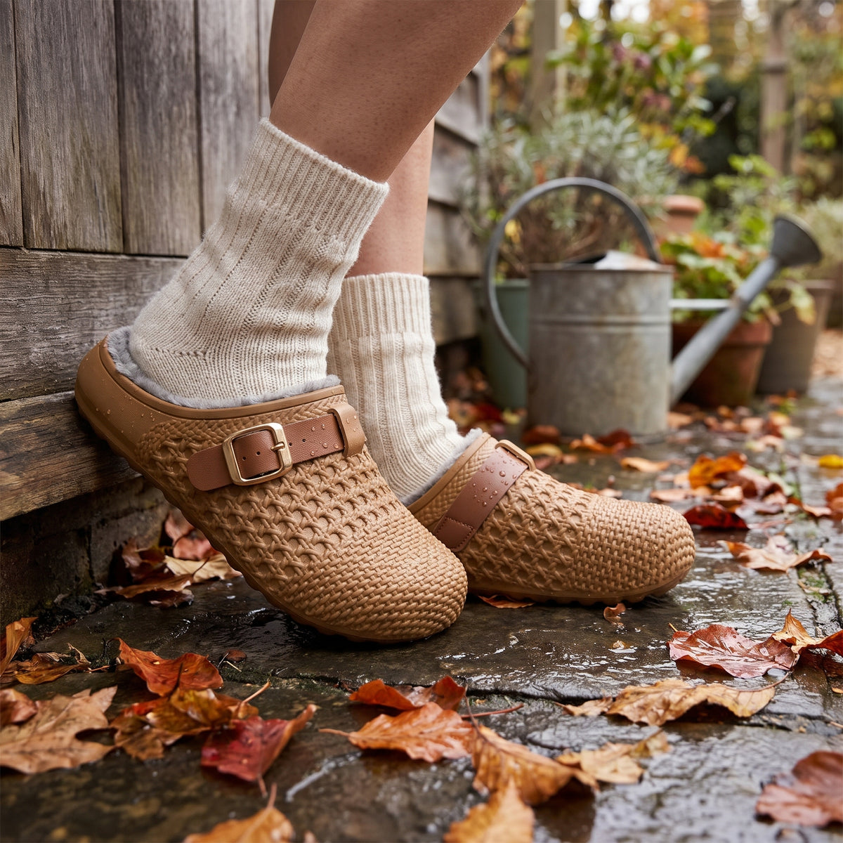 Brown waterproof clog slippers worn outside on a wet garden patio