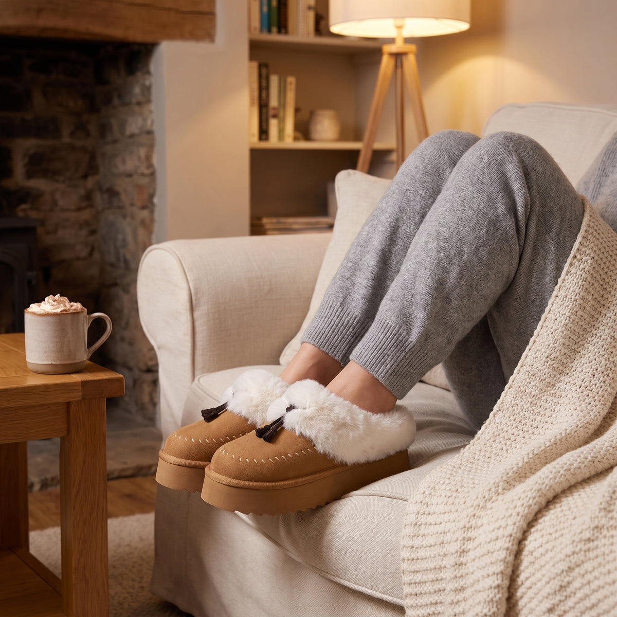 Woman relaxing on a sofa wearing camel fluffy platform slippers