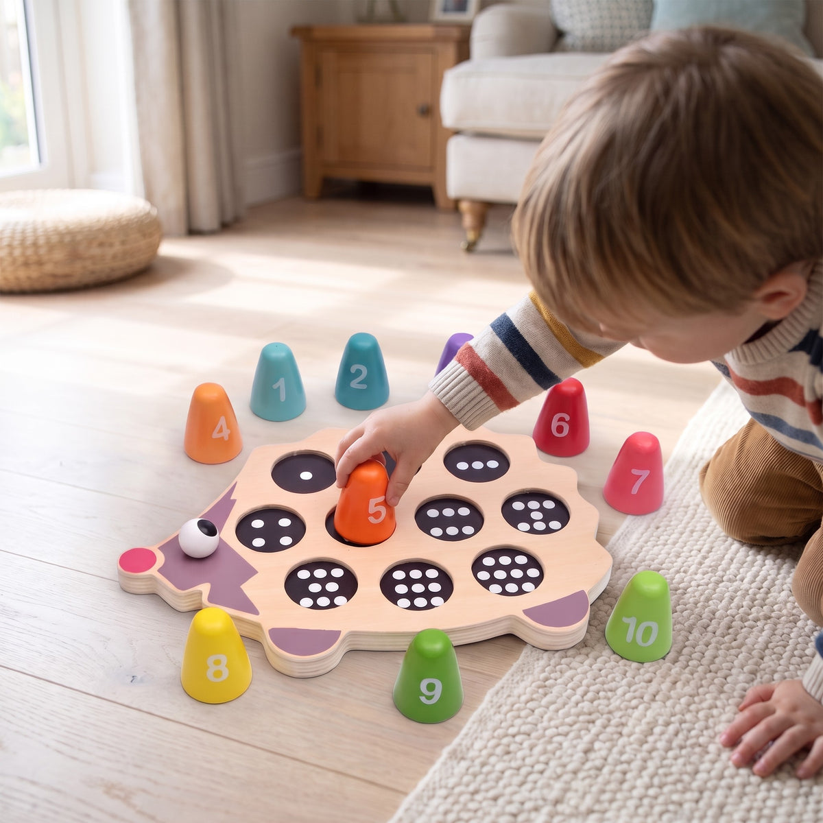 Toddler on a living room floor placing the orange 5 peg into the wooden hedgehog